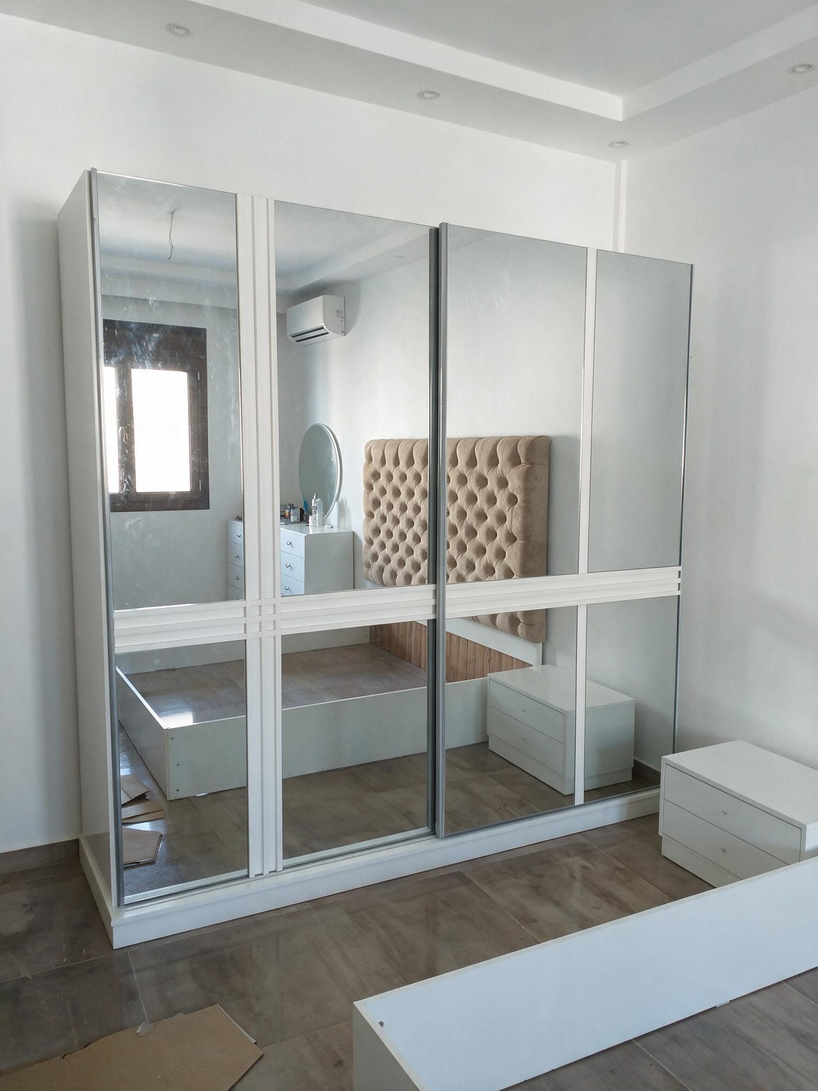 White wardrobe with mirrored doors in a bedroom