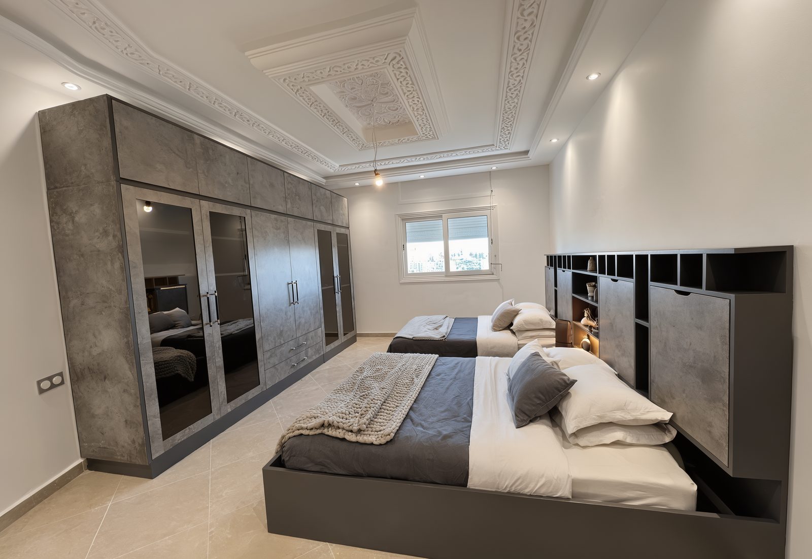 Bedroom with a full-width wardrobe wall opposite two beds